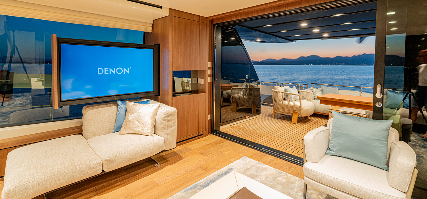 The main salon of Firefly, a luxury motor yacht, leading to the aftdeck at sunset 