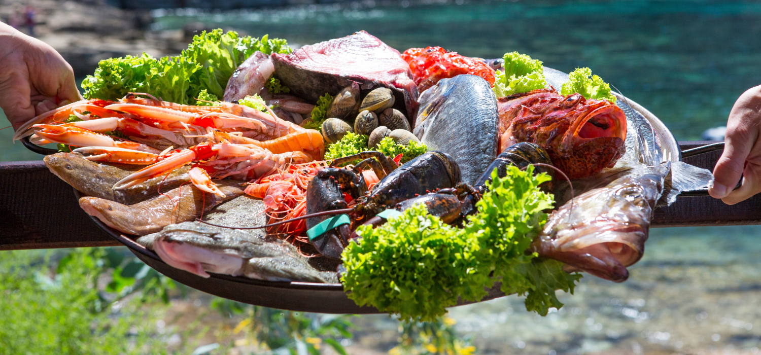 Hand of waitress and waiter with fresh seafood platter